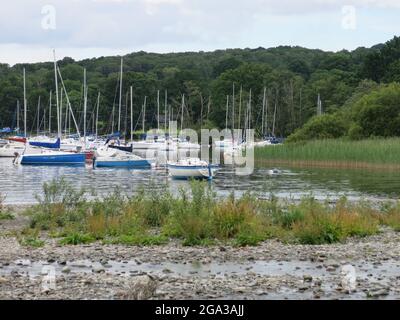 Barche ormeggiate al molo e sul lungolago, Coniston Pier a Coniston Water, il Lake District, estate 2021. Foto Stock
