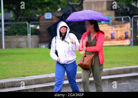 Temporale e pioggia intensa nel centro della città, Manchester, Regno Unito. La gente cerca di evitare la pioggia nel centro della città il 28 luglio 2021. Foto Stock