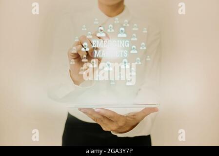 Testo che mostra l'ispirazione mercati emergenti. Panoramica del business nazioni che stanno investendo in capacità più produttiva Lady in Uniform Standing Holding Foto Stock