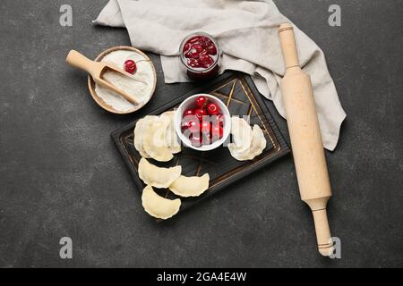 Composizione con gnocchi di ciliegio crudo su sfondo scuro Foto Stock