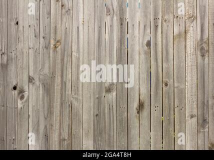 Legno background. Un vecchio recinto di legno fatto di tavole non dipinte con crepe e chiodi Foto Stock