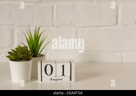 Agosto 1. Il 1 ° giorno del mese, un calendario perpetuo in legno sul posto di lavoro. Ciao agosto. Spazio vuoto per il testo Foto Stock