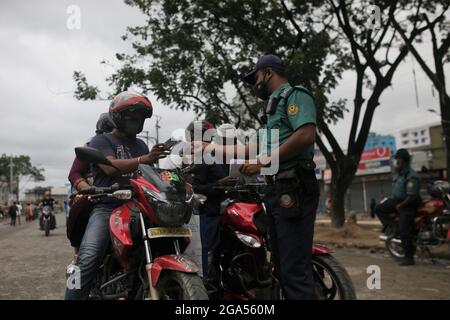 Dhaka, Bangladesh. 29 luglio 2021. Il personale della polizia richiede agli automobilisti il loro movimento in un punto di controllo durante il blocco stretto a livello nazionale per frenare la pandemia del coronavirus Covid-19 a Dhaka. (Credit Image: © MD Mehedi Hasan/ZUMA Press Wire) Foto Stock