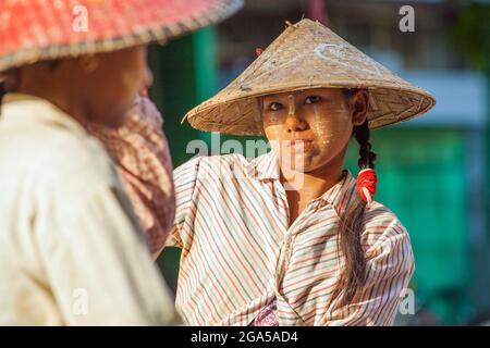 Bel lavoratore manuale birmano con thanaka e cappello conico posa per foto, Mandalay, Myanmar Foto Stock