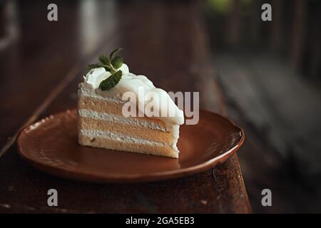 Affettato di deliziosa torta al cocco su tavolo di legno. Foto Stock