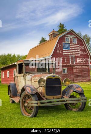 Vecchia macchina di fronte al fienile 'in dio ci fidiamo' a Latah, una città nella contea di Spokane, Washington, Stati Uniti Foto Stock