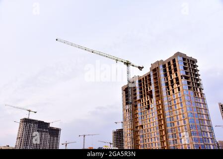 Gru a torre sulla costruzione di un edificio residenziale. Gru su casseri. Costruzione dell'edificio o di case a più piani. Installare la parete di cemento reba Foto Stock