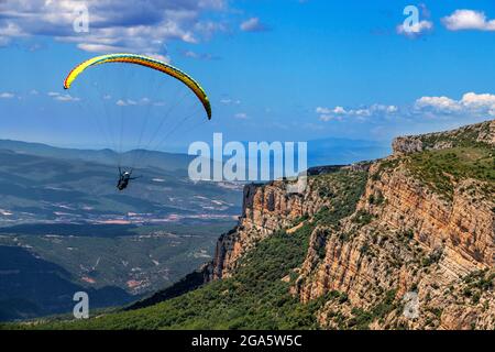 Parapendio gode di un volo ad Ager, Lleida, Catalogna, Spagna. Sorvolando Montsec nei Pirenei catalani e aragonesi. Paesaggi di grande bellezza Foto Stock