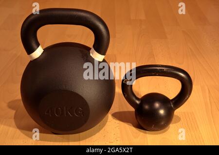 Pesante e leggero kettlebell su sfondo di legno Foto Stock