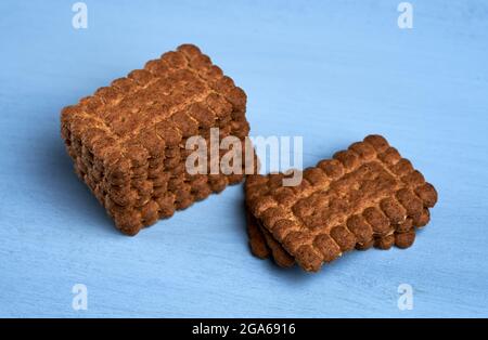 Una pila di biscotti digestivi di caffè di avena su sfondo blu Foto Stock