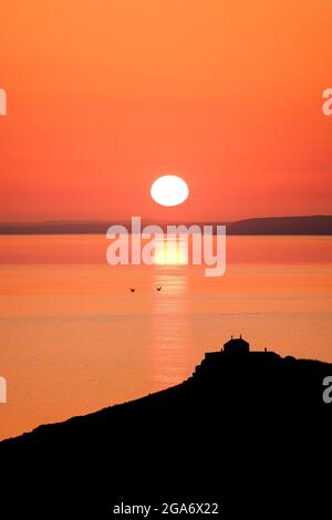 Il sole che sorge sulla baia di St Ives in Cornovaglia, Regno Unito. Foto Stock