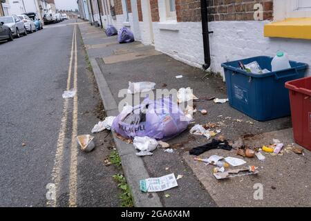 I rifiuti alimentari sono sparsi attraverso il marciapiede in una strada laterale sul mare, dopo che i gabbiani della mattina presto strappati aprono una borsa di plastica, il 26 luglio 2021, a Whitstable, Kent, Inghilterra. Foto Stock