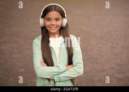 allegro bambino indossare gli auricolari con musica canzone all'aperto godendo melodia, formazione elearning Foto Stock
