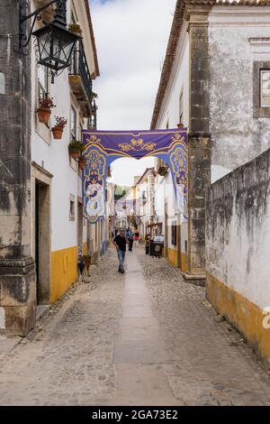 Obidos, Portogallo - 30 giugno 2021: Pittoresca strada con negozi turistici nella midieval città di Obidos Foto Stock