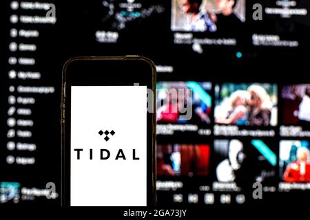 In questa illustrazione fotografica viene visualizzato un logo Tidal su uno smartphone con un sito Web Tidal sullo sfondo. (Foto di Thiago Prudencio / SOPA Images/Sipa USA) Foto Stock