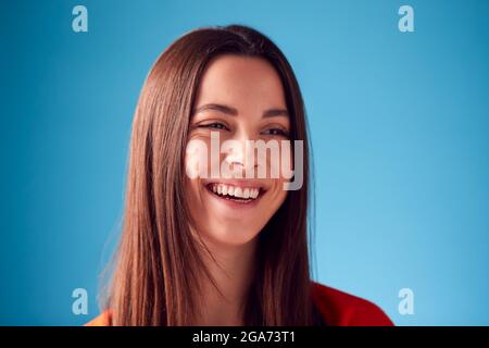 Studio Ritratto di giovane donna fiduciosa contro sfondo blu Foto Stock