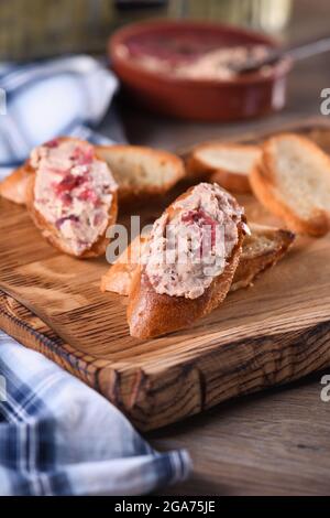 Delicato pato di pollo con purè di mirtilli spalmato su fette di baguette tostate. Cibo di stile country. Foto Stock