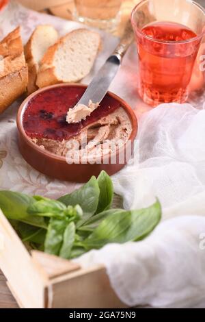 Delicato pato di pollo con mirtilli rossi purei, bevuto in gelatina. Servito con pezzi di baguette e bevanda alla frutta, in una scatola di legno. Cibo di stile country. Foto Stock