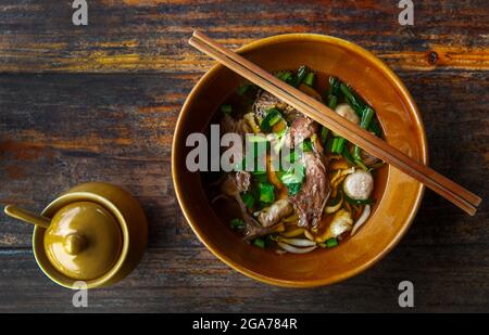 Zuppa cinese trasparente in tradizionale recipiente in ceramica Foto Stock