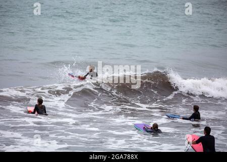 Trevaunance Cove, Cornovaglia, 29 luglio 2021, UN gran numero di Surfers ha approfittato delle onde in Trevaunance Cove davanti a Storm Evert a St Agnes, Cornovaglia. La quarta tempesta estiva, chiamata Summer Storm, dovrebbe portare venti forti e forti precipitazioni durante la notte. Mentre i surfisti erano in acqua i villeggianti anche seduti sulle grandi rocce in cima alla spiaggia come la marea è andato out.Credit: Keith Larby/Alamy Live News Foto Stock