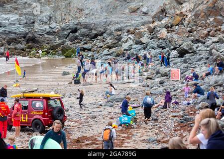 Trevaunance Cove, Cornovaglia, 29 luglio 2021, UN gran numero di Surfers ha approfittato delle onde in Trevaunance Cove davanti a Storm Evert a St Agnes, Cornovaglia. La quarta tempesta estiva, chiamata Summer Storm, dovrebbe portare venti forti e forti precipitazioni durante la notte. Mentre i surfisti erano in acqua i villeggianti anche seduti sulle grandi rocce in cima alla spiaggia come la marea è andato out.Credit: Keith Larby/Alamy Live News Foto Stock