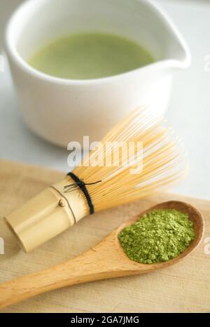 Mescolando la polvere verde di matcha giapponese in un bianco chawan di ceramica con legno di bambù marrone chasen Foto Stock