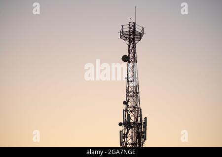 Torre di comunicazione con sfondo blu del cielo del tramonto Foto Stock