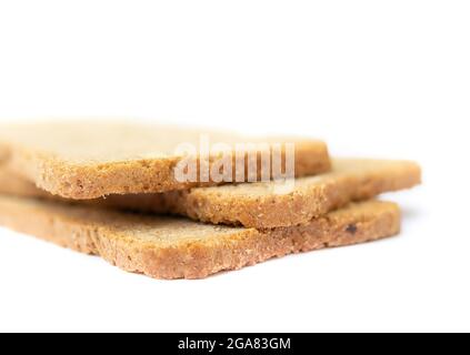 Due cracker di pane di grano tostati. Primo piano di tre sottili fette di pane di forma rettangolare tostate e tostate nuovamente. Spuntino a basso contenuto calorico con fibra ideale Foto Stock