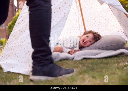 Primo piano di Padre e Figlio che si diverte con Tenda o Tepee accampato in Giardino Foto Stock