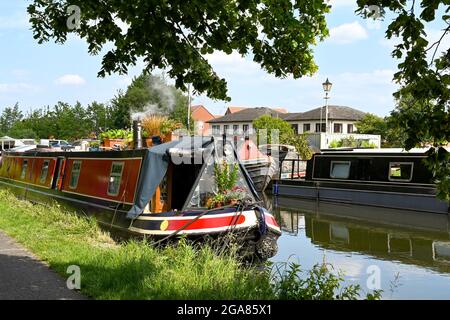 Newbury, Berkshire, Inghilterra - Giugno 2021: Di fronte a una casa galleggiante sul Kennett e sul canale Avon nel centro di Newbury. La vista è incorniciata da alberi Foto Stock
