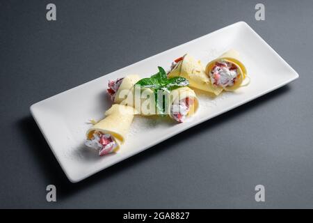 panini sottili con formaggio cremoso e fragola su sfondo nero Foto Stock