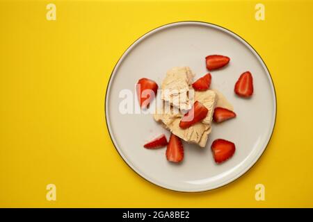 Gelato congelato fruttato con fragola su sfondo giallo, vista dall'alto Foto Stock