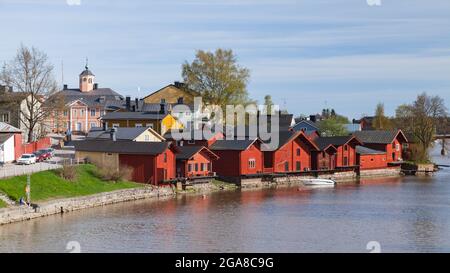 Porvoo, Finlandia - 7 maggio 2016: Città vecchia di Porvoo, vista costiera con vecchie case di legno rosso, gente comune cammina per la strada Foto Stock