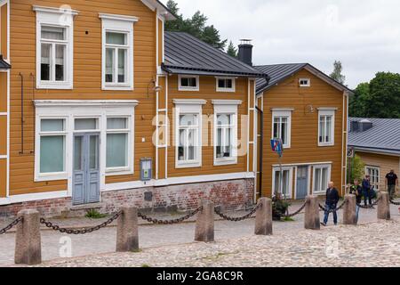 Porvoo, Finlandia - 17 luglio 2016: Vista sulla strada con le case in legno finlandesi gialle, la città vecchia di Porvoo, la gente comune cammina per la strada Foto Stock