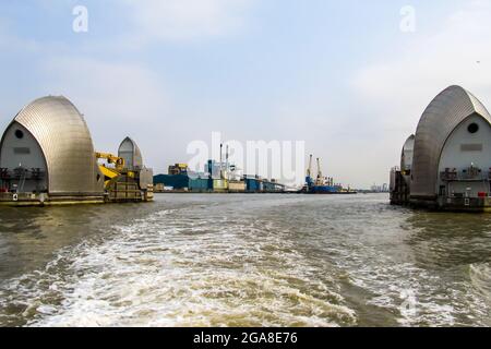 Guardando attraverso due delle conchiglie rivestite in acciaio al largo della barriera del Tamigi nella sua posizione aperta, Silvertown, UK. Questo sistema a barriera retrattile è stato creato Foto Stock