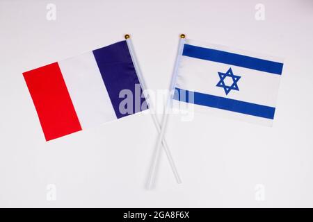 Bandiera della Francia e bandiera d'Israele si incrociavano su sfondo bianco. Isolato. L'immagine illustra il rapporto tra i paesi Foto Stock