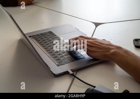 Man mano la digitazione su laptop Foto Stock