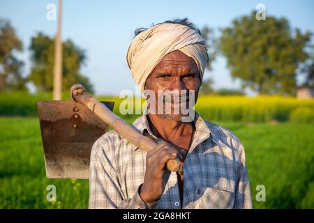 TIKAMGARH, MADHYA PRADESH, INDIA - 23 LUGLIO 2021: Coltivatore indiano in piedi in campo agricolo.