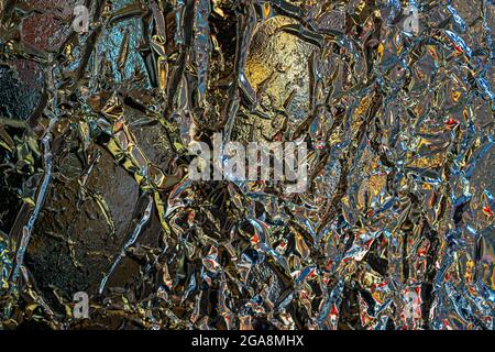 Sfondo astratto colorato e struttura di lamina metallica sminuzzata, rughe, riflessi scenici colorati Foto Stock