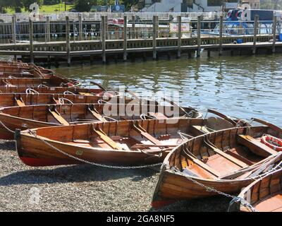 Barche a remi a noleggio si allineano sulla riva di Bowness-on-Windermere, una popolare destinazione turistica nel Distretto dei Laghi Inglesi. Foto Stock