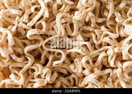 Tagliatelle essiccate o tagliatelle istantanee da vicino. Fondo di cibo testurizzato Foto Stock