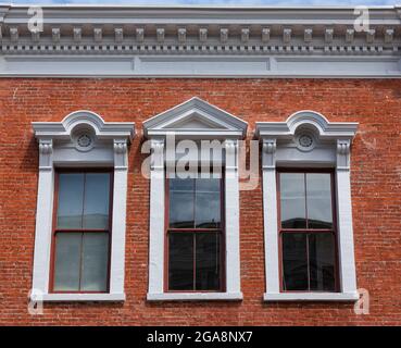 dettagli di tre finestre ad arco in stile classico su un muro di mattoni della casa. Vista laterale storica Victoria BC. Foto di viaggio, foto di strada, selettiva Foto Stock