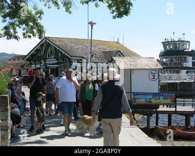 I passeggeri si accodano per il traghetto sul lago Windermere che naviga tra Ambleside e Bowness; una giornata estiva soleggiata in una staycation Lake District. Foto Stock