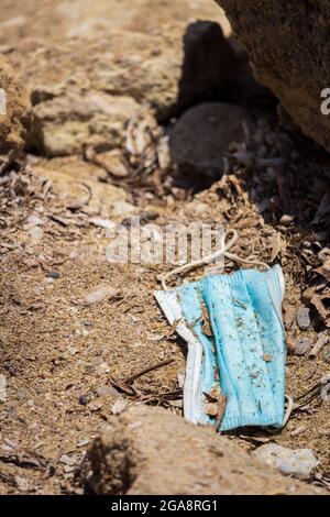 Gettato maschera blu monouso sulla sabbia Foto Stock