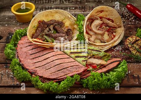 Tacos messicani, quesadilla e burrito con lattuga e condimenti Foto Stock