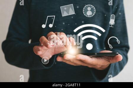 Primo piano mani che tengono smartphone. Uomo che usa il cellulare connessione wi-fi per il marketing e la ricerca di dati e social media su internet.Technology busine Foto Stock