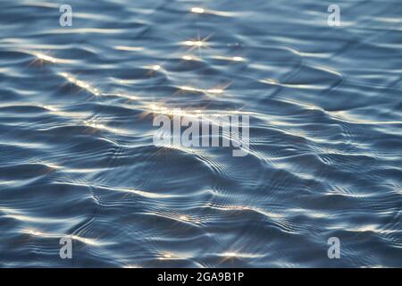 Dettaglio di una luce solare che si riflette in un mare scintillante. sparkler in acqua - sfondo. Acqua di mare con luce solare e ripple. Natura potente e pacifica c Foto Stock