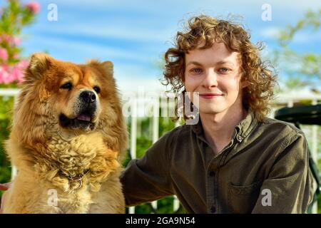 Ritratto di un giovane con un cane di razza Chow Chow Foto Stock