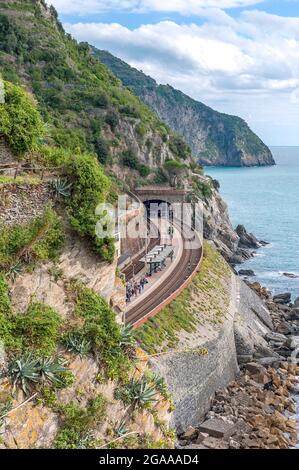 Stazione ferroviaria vicino all'oceano e in fondo a una montagna. Foto Stock