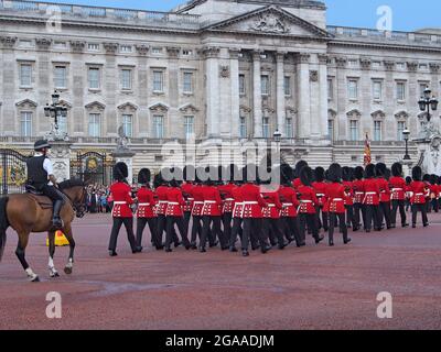 Londra, Inghilterra: Cambio della guardia di fronte a Buckingham Palace con solidaristi in cappotti rossi che portano fucili con baionette Foto Stock